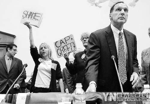 ■2008年10月6日，雷曼兄弟首席执行官弗尔德向众议院政府改革委员会作证。抗议者在他身后举标语示威